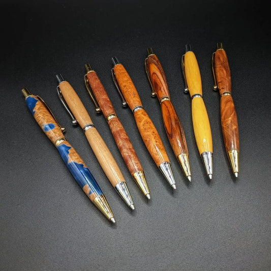 Stylo artisanal fait à la main en bois et résine acrylique colorée, posé sur un support avec fond noir