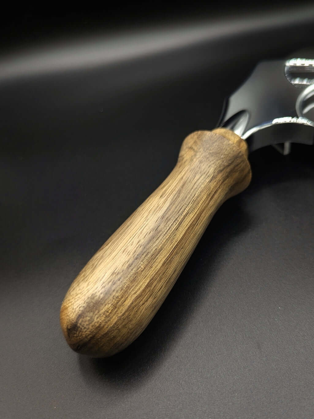 Stylo artisanal fait à la main en bois et résine acrylique colorée, posé sur un support avec fond noir