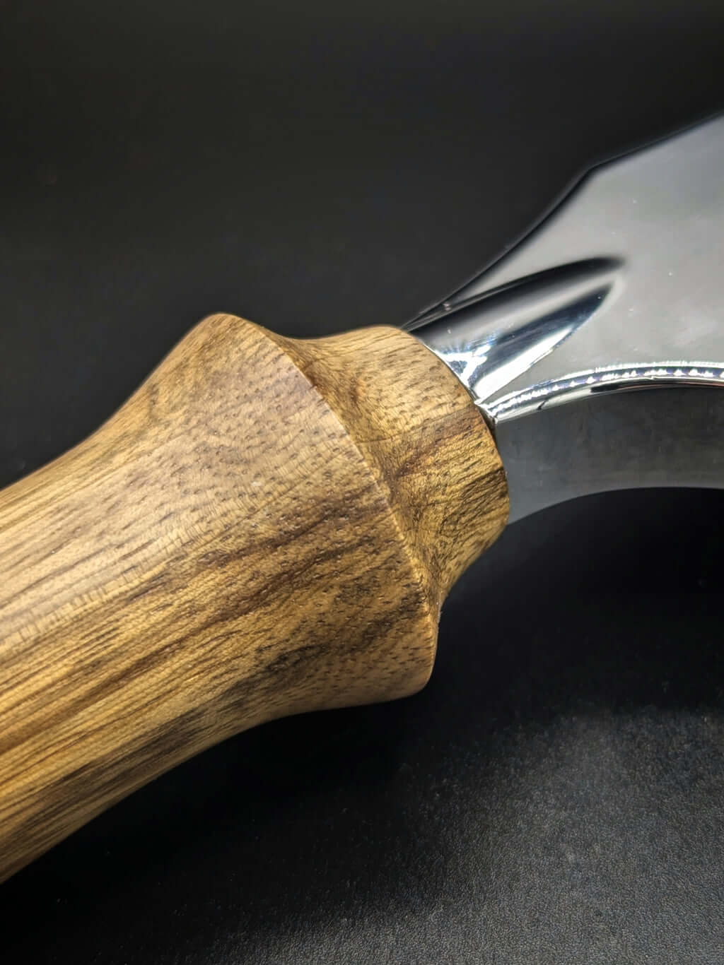 Stylo artisanal fait à la main en bois et résine acrylique colorée, posé sur un support avec fond noir