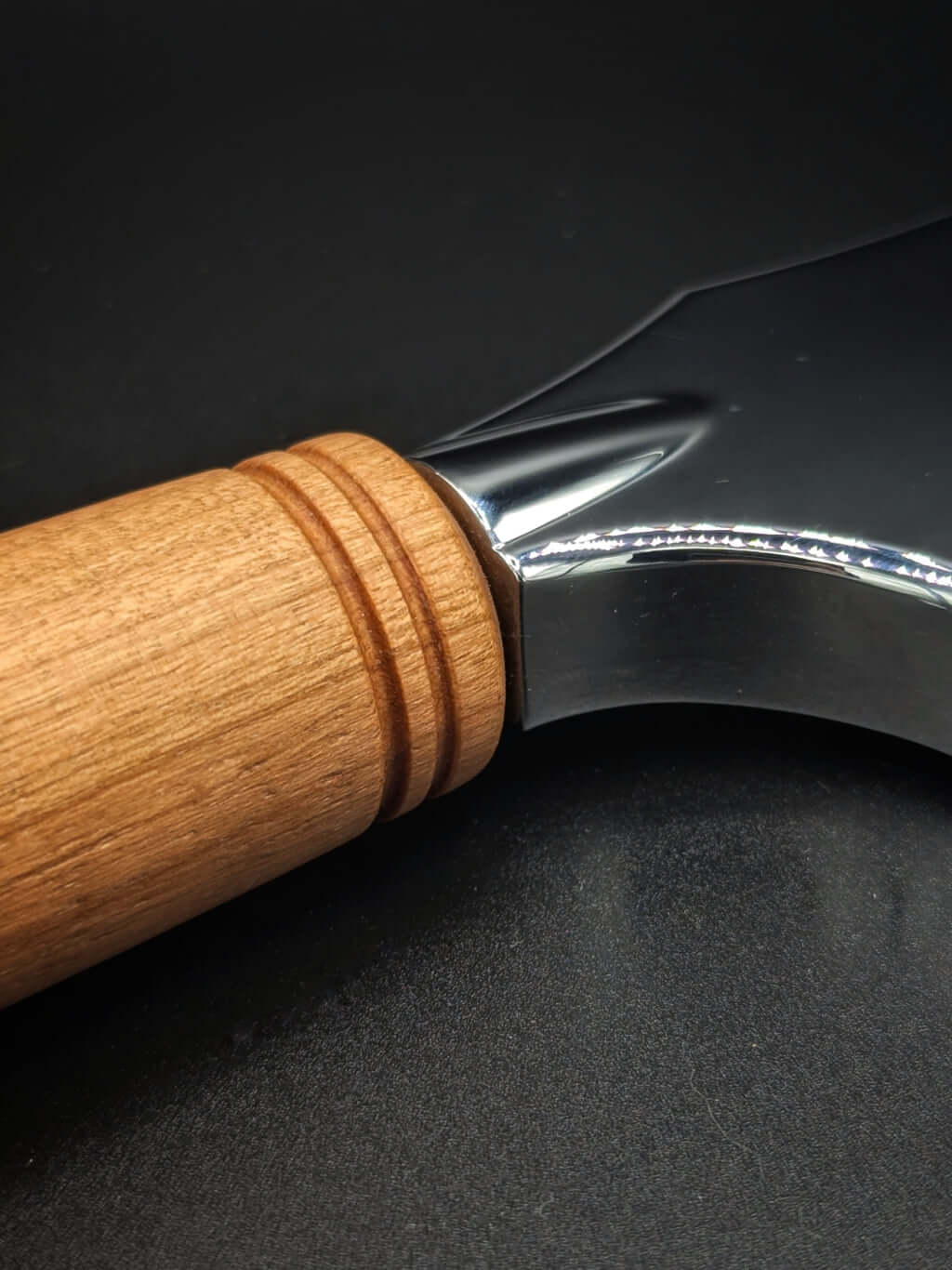 Stylo artisanal fait à la main en bois et résine acrylique colorée, posé sur un support avec fond noir