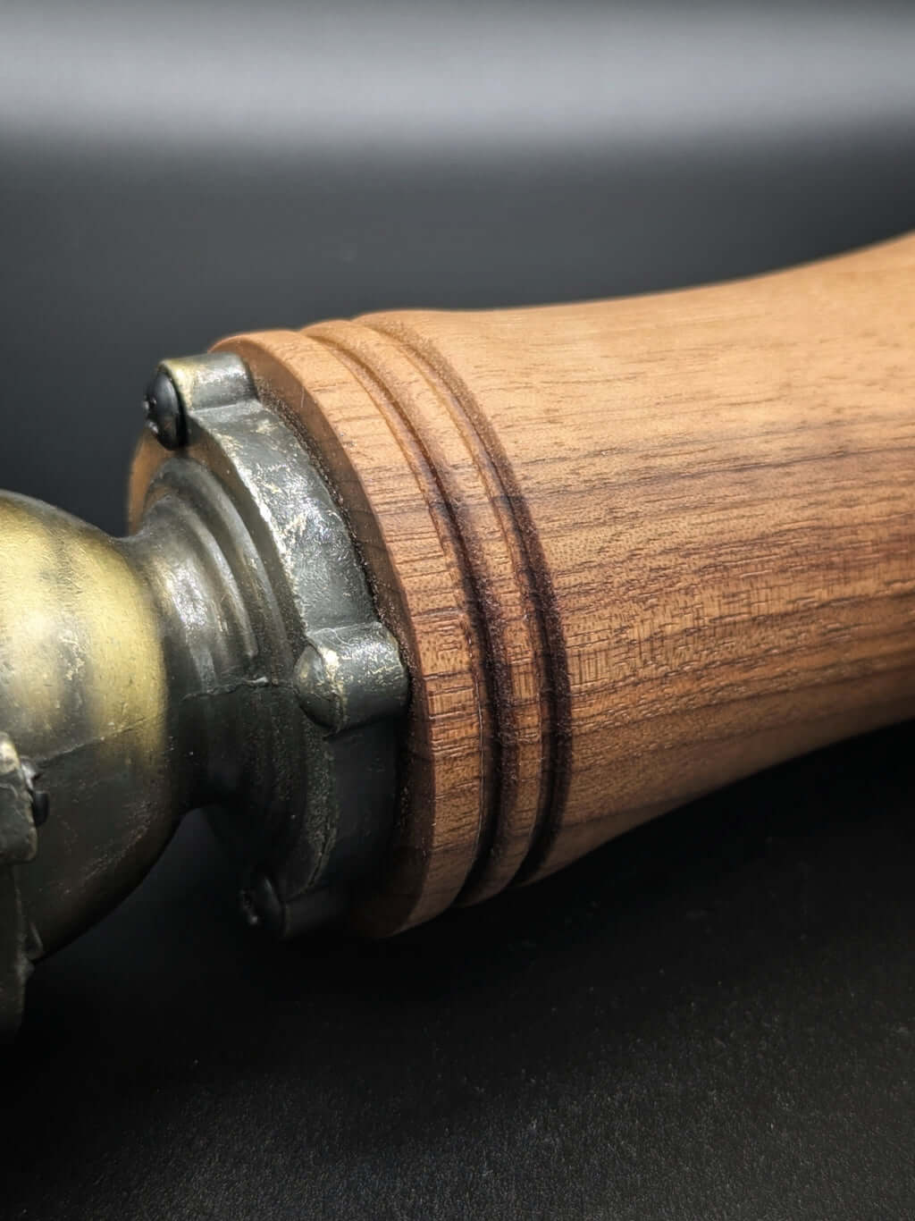 Stylo artisanal fait à la main en bois et résine acrylique colorée, posé sur un support avec fond noir
