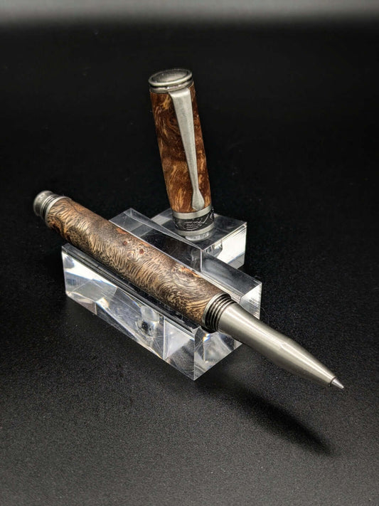 Stylo artisanal fait à la main en bois et résine acrylique colorée, posé sur un support avec fond noir